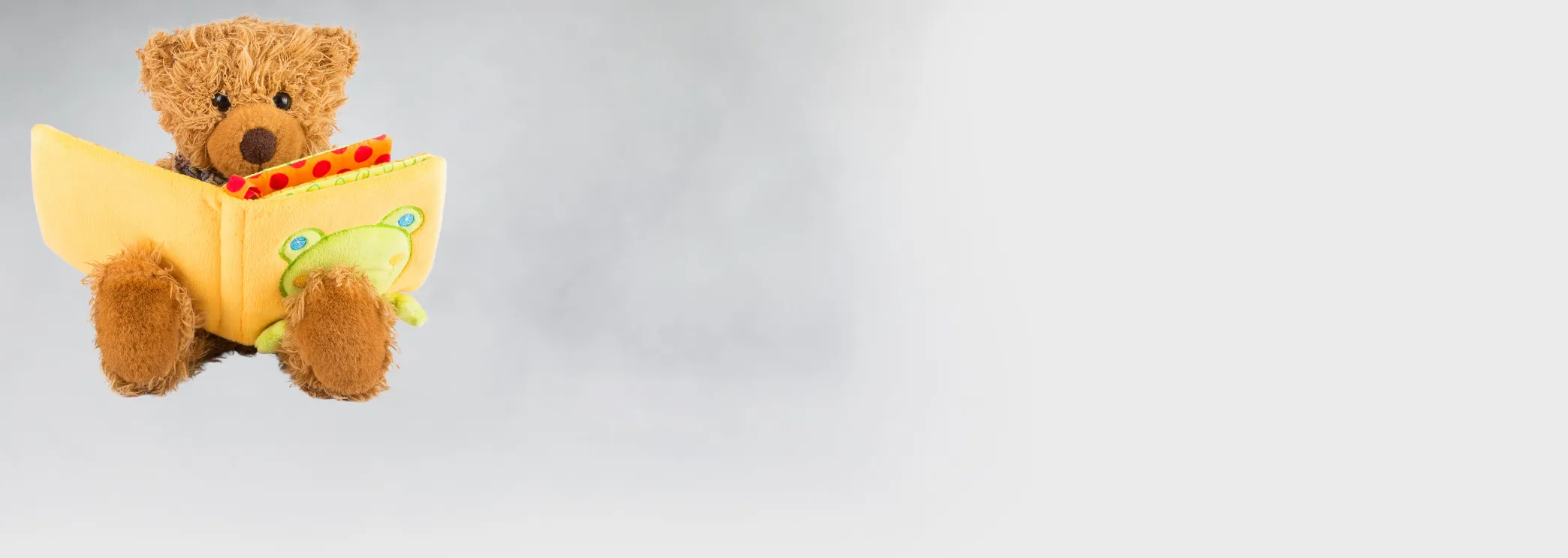 Kinderbücher Symbolbild mit Babybuch und Teddybär